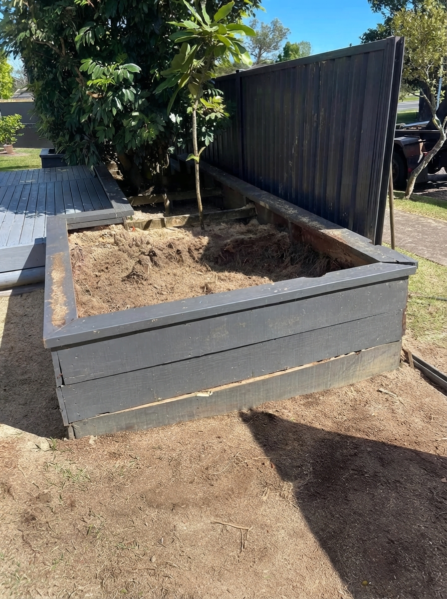 After stump grinding: planter box cleared of the stump with level soil ready for planting